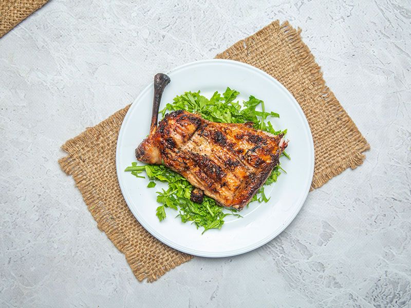 Quarter grilled chicken thigh